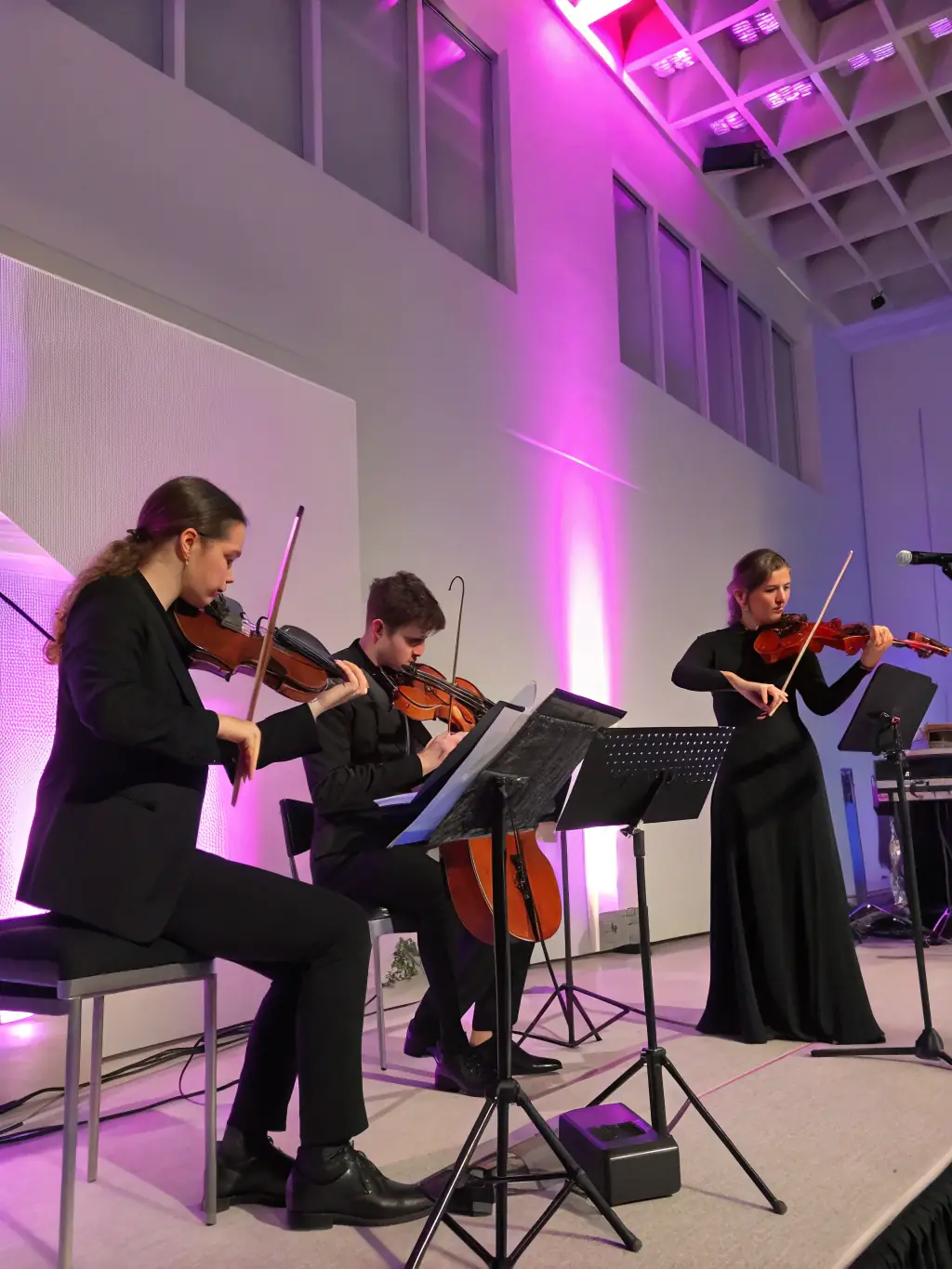 A photograph capturing the QUATUOR 4444 performing live in a concert hall, showcasing their musical talent and stage presence. The image should convey the energy and passion of their performances.